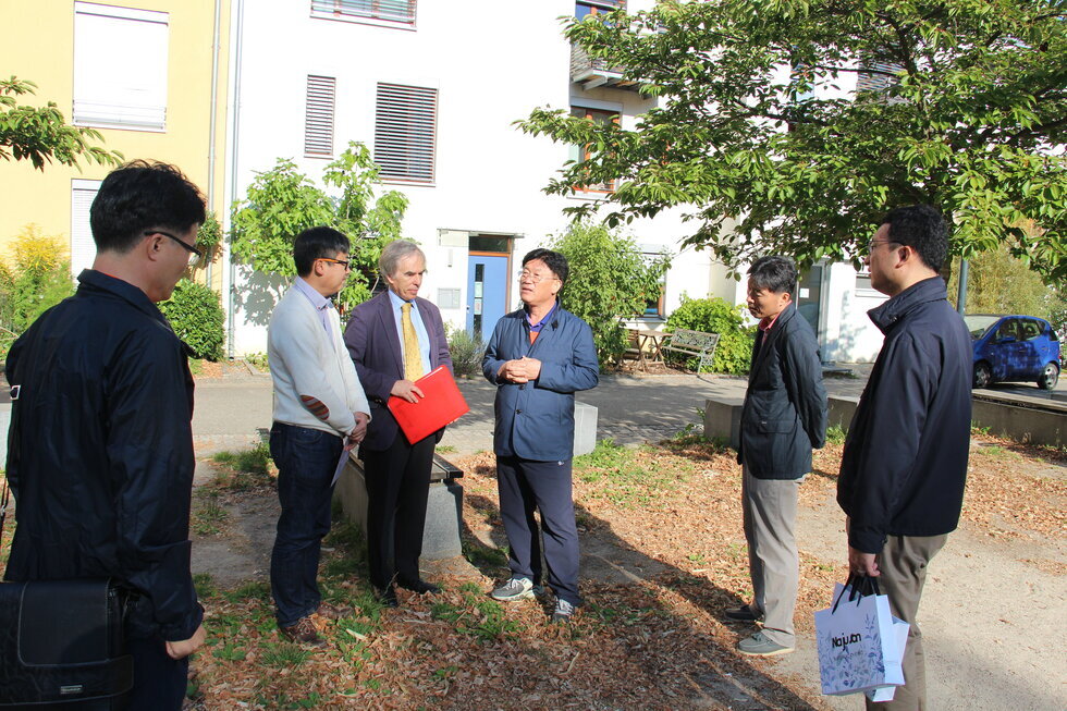멀리서 찍은 독일 관계자와 이야기를 나누는 장면