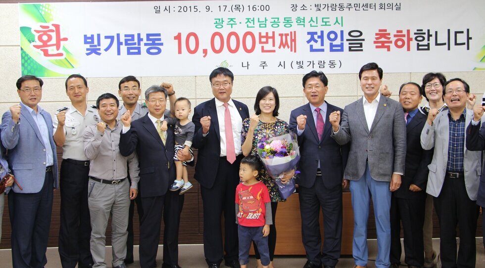 10000번째 전입을 축하하는 관계자들과 함께 기념사진 촬영