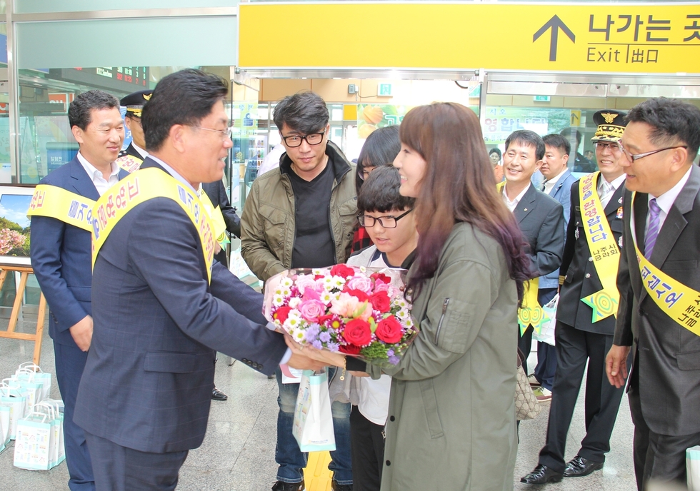 고향에 방문한 가족들에게 꽃다발을 전달하는 시장님
