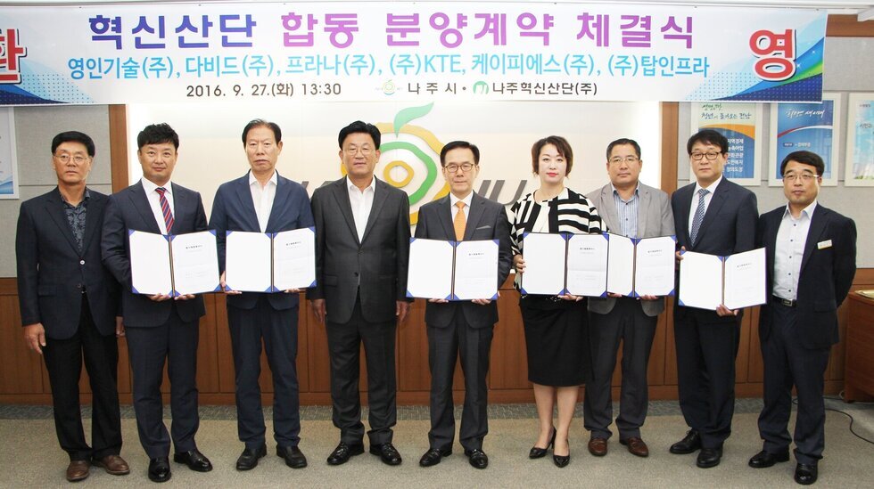 환영, 혁신산단 합동 분양계약 체결식 , 영인기술(주), 다비드(주), 프나라(주), (주)KTE 케이피에스 (주) (주)탑인프라 현수막 밑에서 단체사진 찍는 모습