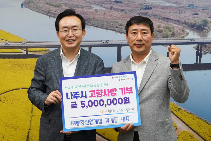  살기좋은 행복 나주 앞서가는 으뜸 나주 내고향 나주! 사랑하고 응원합니다. 나주시 고향사랑 기부 금 5,000,000원 함께 합니다. 같이 합니다.  (주)봉화산업개발 김계동 대표 팻말을 들고 있는 윤병태 시장과 김계동 대표