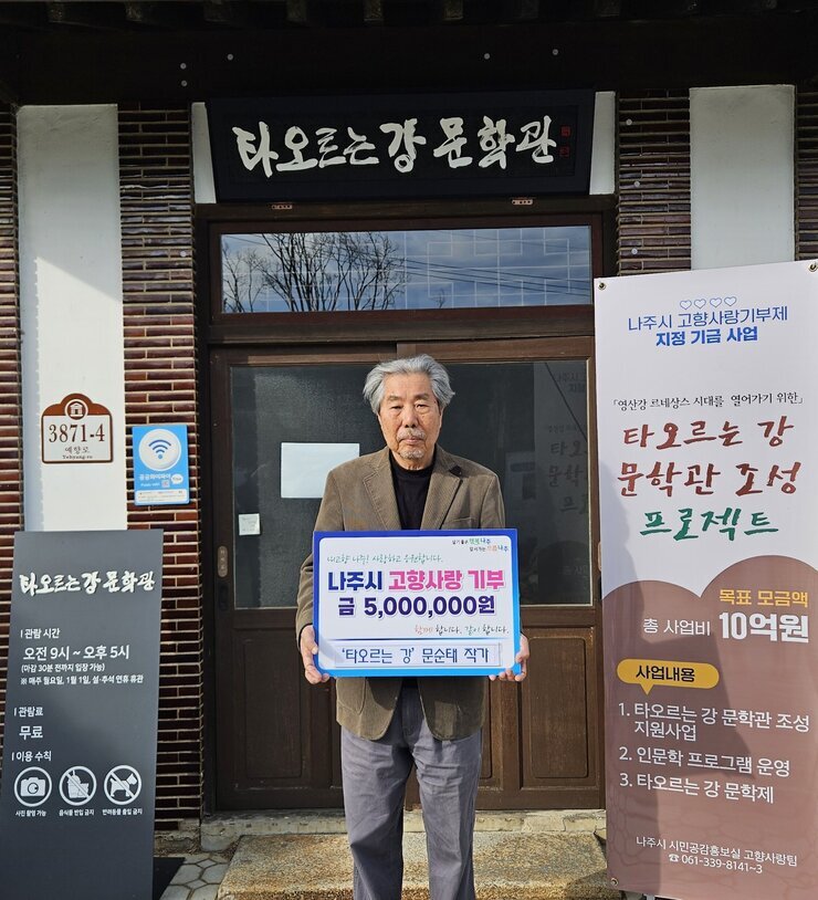 타오르는 강 문학관 3872-4 예향로 타오르는 강 문학관 |관람시간 오전 9시~오후5시(마감 30분 전까지 입장 가능) ※매주 월요일, 1월1일, 설,추석 연휴 휴관 |관람료 무료 |이용수칙 사진촬영가능 음식물 반입 금지 반려동물 출입 금지 라고 적힌 안내판. 나주시 고향사랑기부제 지정 지금 사업 「영산강 르네상스 시대를 열어가기 위한」타오르는 강 문학관 조성 프로젝트 목표 모금액 총 사업비 10억원 사업내용 1.타오르는 강 문학관 조성 지원사업 2.인문학 프로그램 운영 3.타오르는 강 문학제 나주시 시민공감홍보실 고향사랑팀 061-339-8141~3 현수막. 살기좋은 행복 나주 앞서가는 으뜸 나주 내고향 나주! 사랑하고 응원합니다. 나주시 고향사랑 기부 금 5,000,000원 함께 합니다. 같이 합니다. '타오르는 강' 문순태 작가 라고 적힘 팻말을 들고 있는 문순태 작가