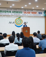 나주영산강축제 시민홍보단 나주시장이 단상에서 인사말을 하고 있는 모습과 참석자들이 앉아서 듣고 있는 뒷모습 전면