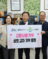 제주시-나주시 고향사랑기부 상호 교차 기부 응원 이라고 적힌 팻말을 들고 화이팅 포즈로 촬영하는 사진