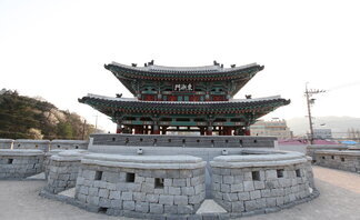 동점문 정면을 찍은 사진. 가지련한 돌로 성벽이 쌓여 있고 그 뒤로 2층짜리 기와가 있고 동점문이라고 한자로 쓰여진 현판걸려 있음.