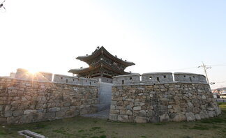 동점문 측면을 찍은 사진. 성벽이 보이고 그 뒤로 2층짜리 기와에 동점문이라는 현판이 걸려 있음.
