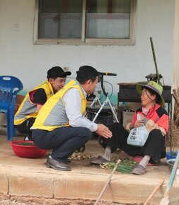 밑반찬을 받고 감사해하는 할머니와 대화중인 봉사자들