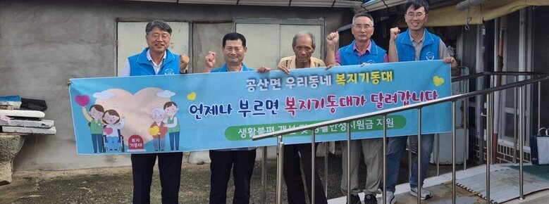 공산면 우리동네 복지기동대원들과 공산면 주민이 함께 '공산면 우리동네 복지기동대 언제나 부르면 복지기동대가 달려갑니다' 플랜카드를 들고있는 모습