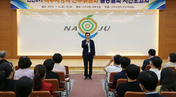 시민보고회에서 마이크를 들고 이야기를 하고있는 나주시장과 경청하는 시민들