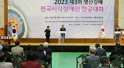 영산강배 전국 시각장애인 한궁대회 개회식 참석자들의 뒷모습이 보이고 나주시장이 환영사를 하고 있는 모습