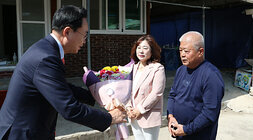 따뜻한 보금자리 3호 주택 준공식  나주시장이 주택 공사 담당 대표 2명에게 꽃다발을 증정하고 있는 모습