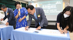 나주시 가족센터 개소식 나주시장이 무대 앞에 마련된 테이블에서 축하메세지를 작성하고 있는 모습