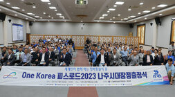 One Korea 피스로드 2023 전남 나주시 통일대장정 출정식  플랭카드를 앞에 두고 참여자들이 앉아서 기념촬영을 하고 있는 모습