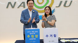 나주시 취업청년 임대주택 동, 호수 추첨 및 입주 설명회 나주시장과 동, 호수 추첨을 완료한 여성 청년이 기념촬영을 하고 있는 모습