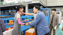 추석 명절 배 선과장 방문 나주시장이 선과장에서 배 분류 작업을 하고 있는 여성분과 두손을 맞잡으며 인사를 나누는 모습