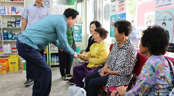 공산면 상가 방문 나주시장이 공산면 약국을 방문하여 약을 사러 오신 여성 어르신과 악수를 나누며 인사를 나누는 모습