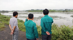 호우 및 강풍 피해지구 현장 점검 나주시장이 세지면의 한 제방에 올라 물이 가득 차 있는 곳을 바라보고 있는 뒷모습 옆에 담당 과장이 설명을 하고 있는 뒷모습