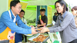 영산강축제 한우(한돈)고기 소비 촉진행사 ㅇ나주시장이 한돈 소비촉진 부스에서 한돈으로 만든 음식을 여성 관광객에게 나눠주고 있는 모습