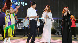 영산강축제 뮤지컬 빅쇼 나주시장이 주무대 위에서 여성 뮤지컬 배우의 유도로 여성배우를 바라보고 있는 모습 양 옆으로 뮤지컬 여성 배우 2명이 박수를 쳐주고 있는 모습