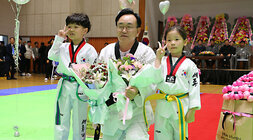 나주시장기 태권도대회  나주시장이 남,녀 어린이에게 감사의 꽃다발을 받고 기념촬영을 하고 있는 모습