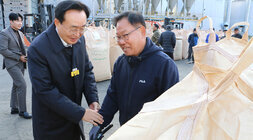 다도면 DSC 수매현장 방문 나주시장이 톤백 앞에서 남성 품질 관리원의 한 손을 잡고 인사를 나누는 모습