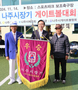 제25회 나주시장기 게이트볼대회 나주시장과 전년 우승팀의 대표자가 우승기를 들고 기념촬영을 하고 있는 모습