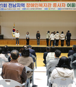 전남지역 장애인복지관 종사자 어울마당 행사 관계자가 무대 위에서 시상을 하고 있는 모습과 참석자들의 앉아 있는 뒷모습