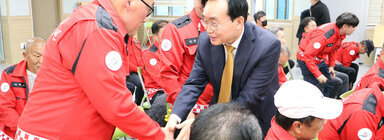 나주시 산불진화대 격려 나주시장과 산불진화대원 남성분이 손을 잡으며 인사를 나누고 있는 모습