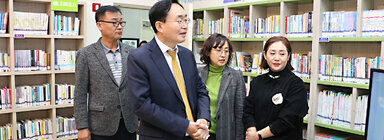 LH5단지 프로그램 성과나눔 전시회 나주시장이 LH5단지 도서관의 프로그램에 대해 관계자의 설명을 듣고 있는 모습