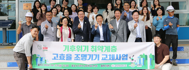 한전 KDN 취약계층 고효율 조명기기 교체 후원  나주시장과 한전KDN사장 및 시청 직원, 한전KDN 직원들이 플래카드를 펼치고 손하트를 하며 기념촬영을 하고 있는 모습