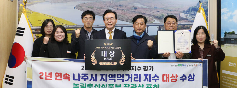 나주시 지역먹거리 지수 대상 수상 나주시장과 담당부서 직원들이 플래카드를 펼치고 기념촬영을 하고 있는 모습