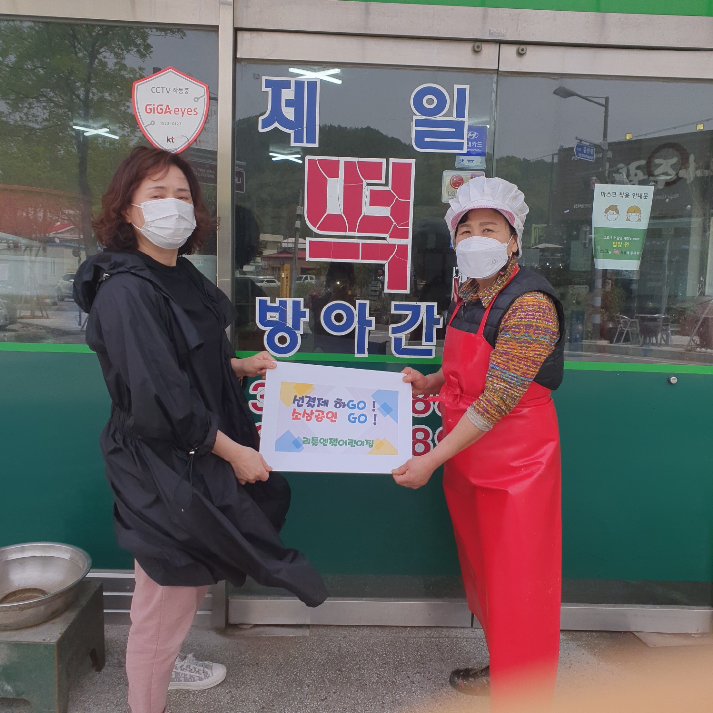 선결제 캠페인 안내판을들고 가게정문앞에서 촬영한 사진