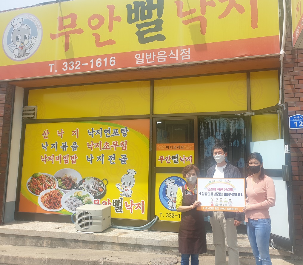 선결제 캠페인 안내판을들고 가게정문앞에서 촬영한 사진