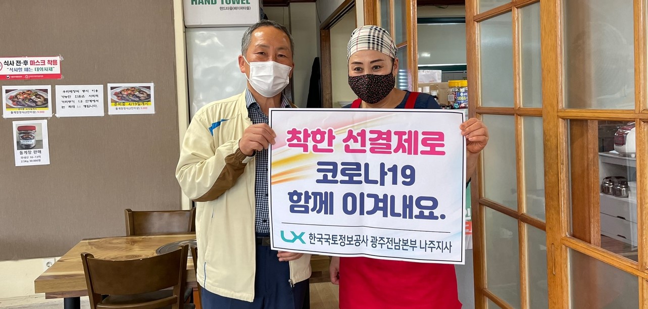 선결제 캠페인 안내판을들고 가게안에서 촬영한 사진