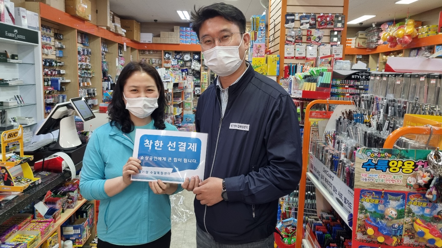 선결제 캠페인 안내판을들고 가게안에서 촬영한 사진