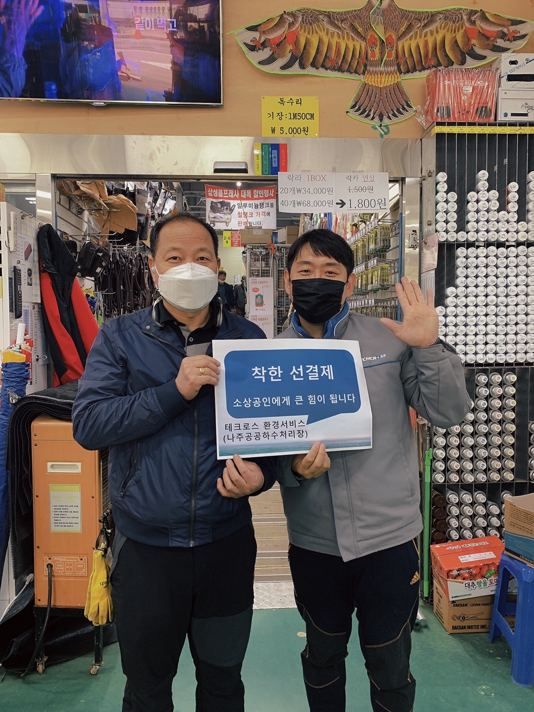 선결제 캠페인 안내판을들고 가게 안에서 촬영한 사진