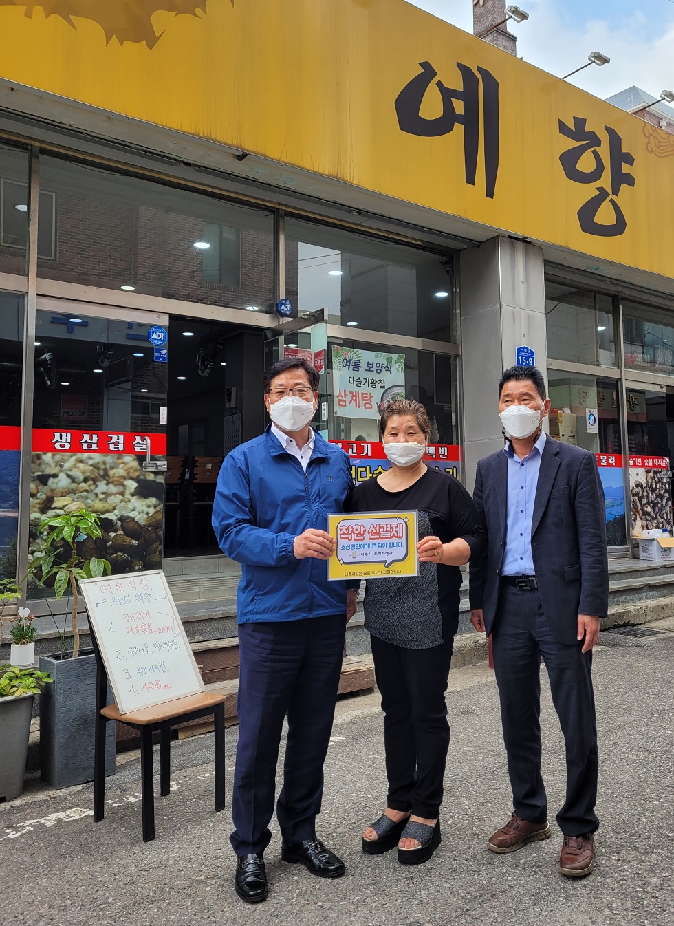 선결제 캠페인 안내판을들고 식당앞에서 촬영한 사진