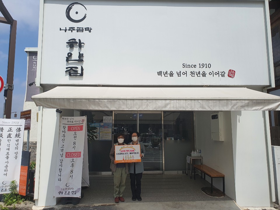 선결제 캠페인 안내판을들고 나주곰탕 하얀집 앞에서 촬영한 사진 