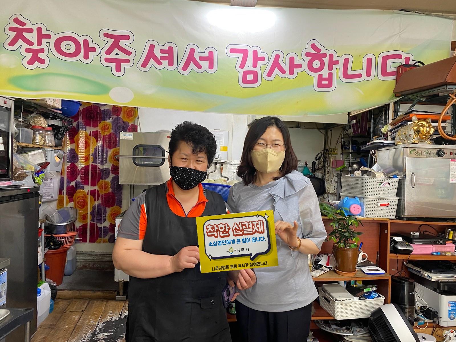 착한선결제 캠페인 안내판을 들고 촬영한 사진