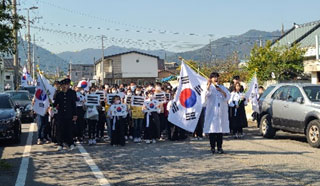 어린이와 청년들이 한복을 입고 태극기를 들고 있는 모습