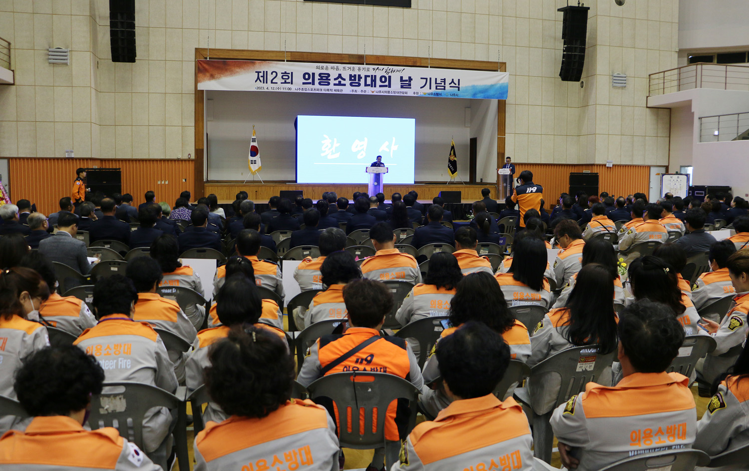 의용소방대의 날 기념식 참서자들의 뒷모습이 보이고 의용소방대 연합회장의 환영사 모습