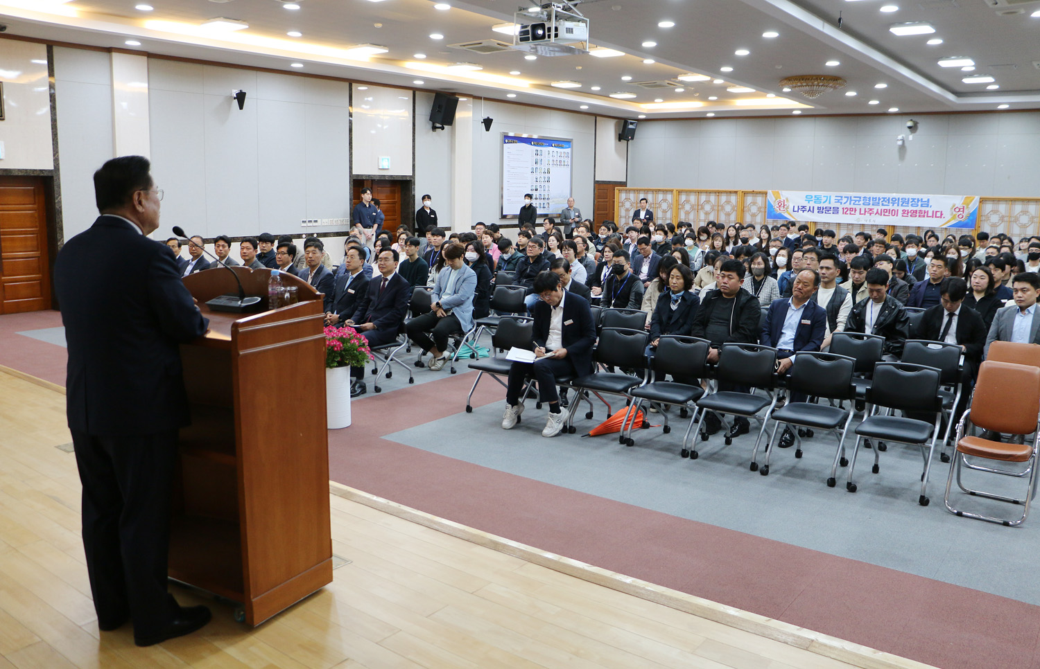 제7회 더 큰 나주아카데미 단상 위 강단 뒷편에서 강사님의 우측면이 보이고 참석자들의 얼굴이 보이는 모습 전면