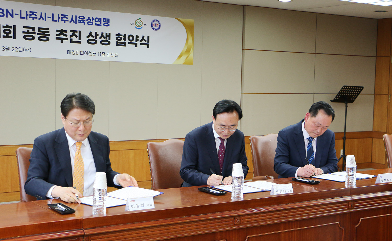 마라톤대회 공동추진 상생 협약식 (나주시-MBN-나주시 육상연맹) 나주시장, 매경 대표이사, 시 육상연맨 회장의 협약서에 서명하는 모습