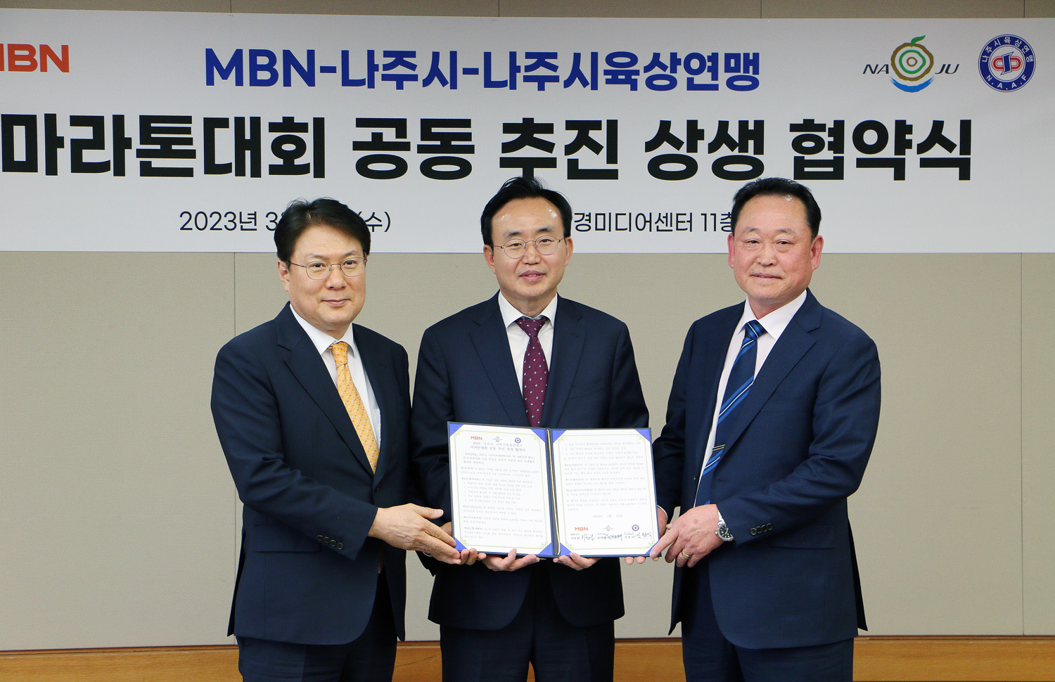 마라톤대회 공동추진 상생 협약식 (나주시-MBN-나주시 육상연맹) 협약서를 들고 기념촬영하고 있는 나주시장과 매경 대표이사, 시 육상연맹 회장 모습