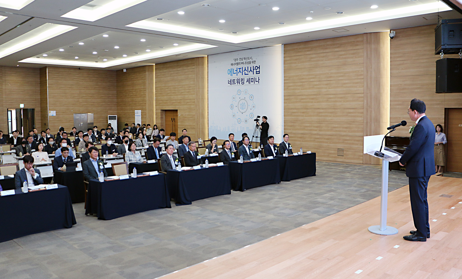에너지밸리 MG 조성 네트워킹 세미나 단상 뒷쪽에서 촬영한 참석자들의 앉아 있는 모습과 나주시장의 축사 뒷모습