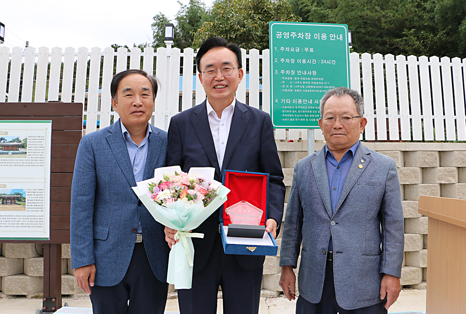 왕곡면 송죽2구 귀엽마을회관 준공식 마을대표 어르신 2명과 함께 나주시장이 기념촬영을 하고 있는 모습