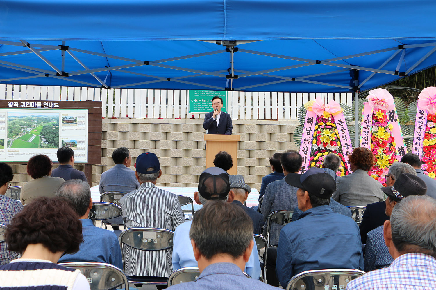 왕곡면 송죽2구 귀엽마을회관 준공식 나주시장의 축사모습과 참석자들의 뒷모습