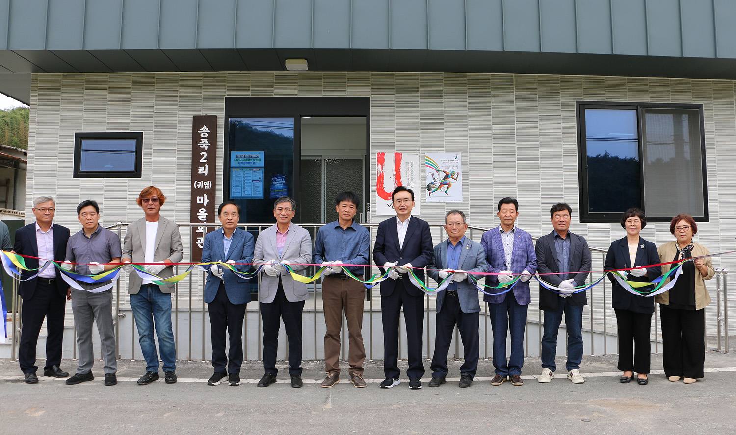 왕곡면 송죽2구 귀엽마을회관 준공식 나주시장과 내빈 및 마을 대표분들이 테이프 컷팅 기념촬영을 하고 있는 모습