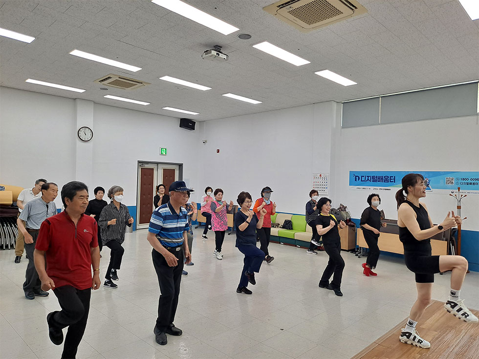 교육장에서 생활체조를 교육중인 강사와 배우는 교육생들 모습