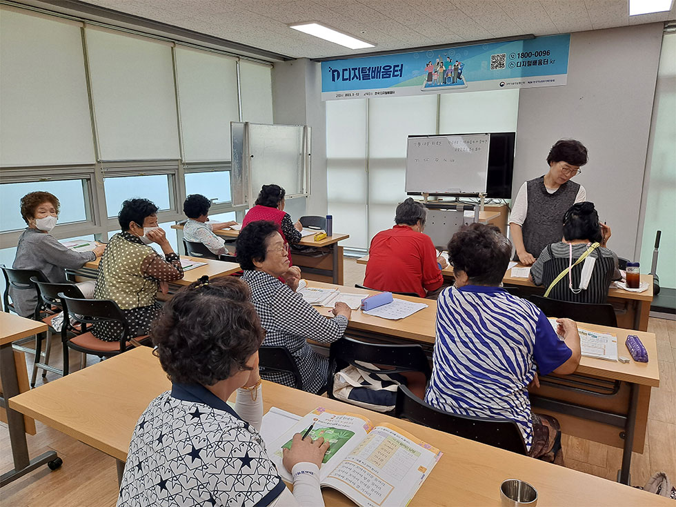 교육장에서 한글을 교육중인 강사와 배우는 교육생들 모습